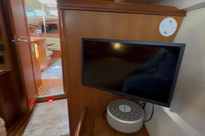 Slide: The Image of 2007 Hunter 44 Deck Salon interior with TV and wooden cabinetry. - 65