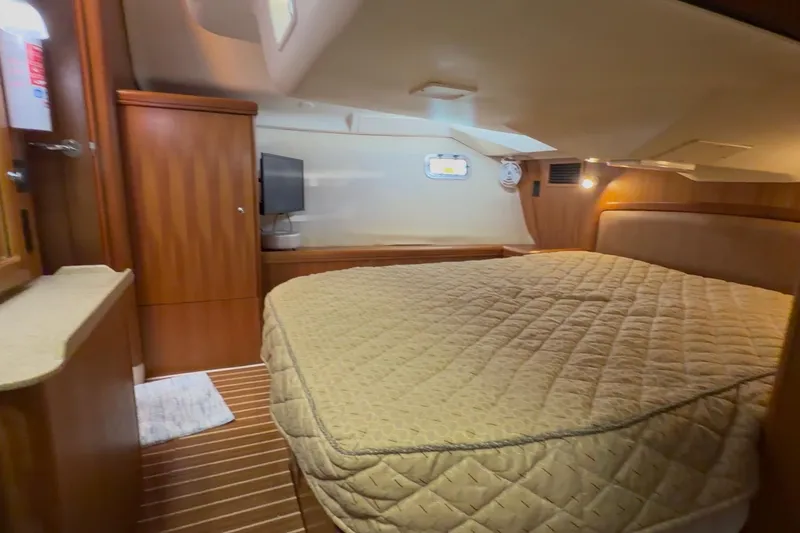 Slide: The Image of Luxurious interior of 2007 Hunter 44 Deck Salon yacht with cozy bed and wooden cabinetry. - 68