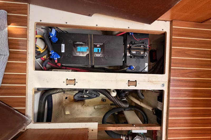 Slide: The Image of Battery compartment of a 2007 Hunter 44 Deck Salon sailboat, showing wiring and components. - 76