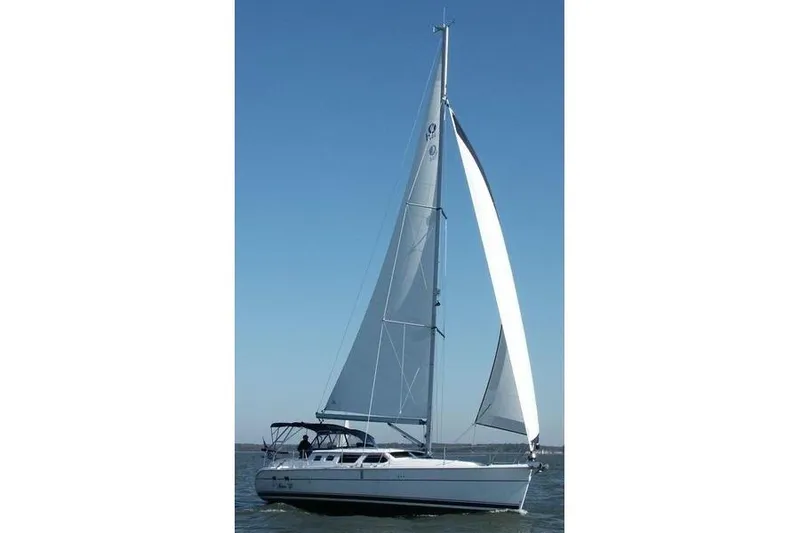Slide: The Image of 2007 Hunter 44 Deck Salon sailboat on open water under clear blue sky. - 77