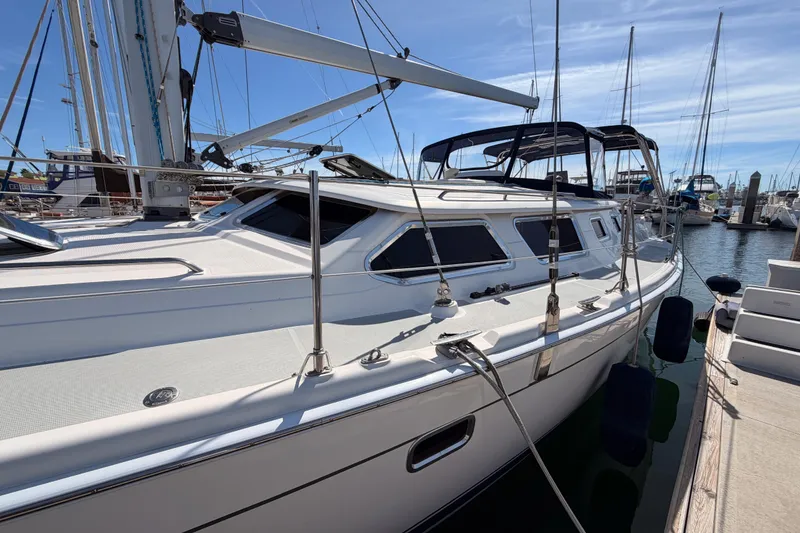 Slide: The Image of 2007 Hunter 44 Deck Salon sailboat docked at marina under clear blue sky. - 8