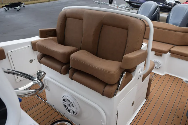 Slide: The Image of 2022 Sea Hunt Ultra 275 SE boat with brown cushioned seating and steering wheel. - 16