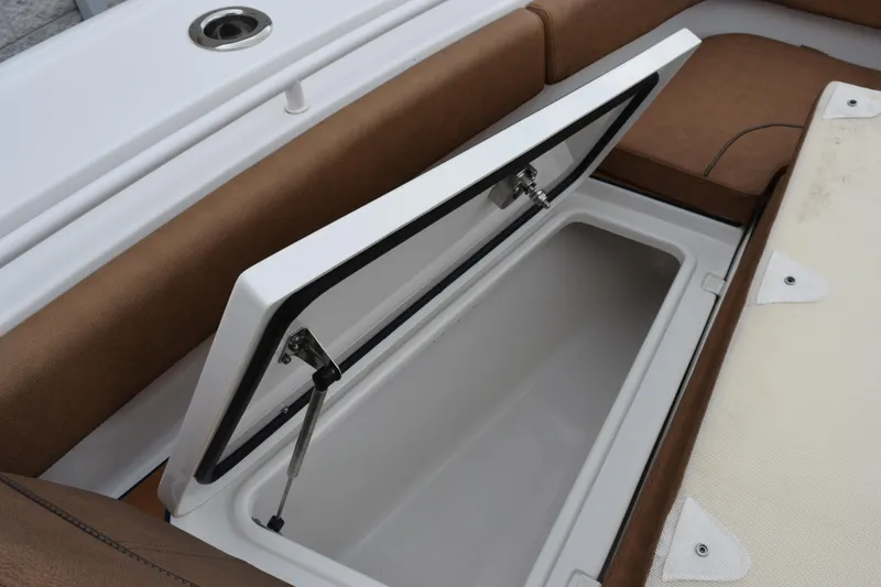 Slide: The Image of Open storage compartment on 2022 Sea Hunt Ultra 275 SE boat with brown seating. - 19