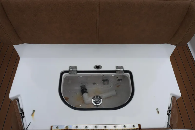Slide: The Image of 2022 Sea Hunt Ultra 275 SE boat storage compartment with brown seating and white interior. - 21