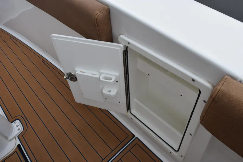 Slide: The Image of 2022 Sea Hunt Ultra 275 SE boat storage compartment with open door and cushioned seating. - 23
