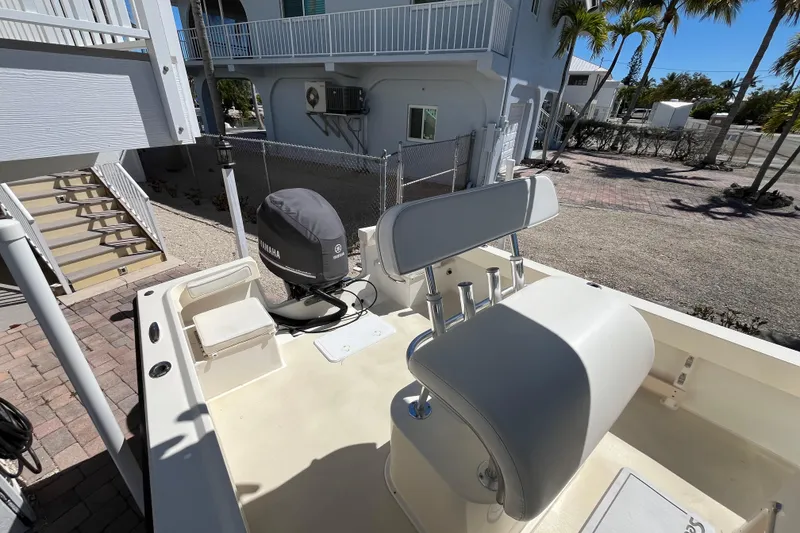 Slide: The Image of 2009 Parker 2300 Special Edition boat with Yamaha engine, parked near a coastal home. - 11