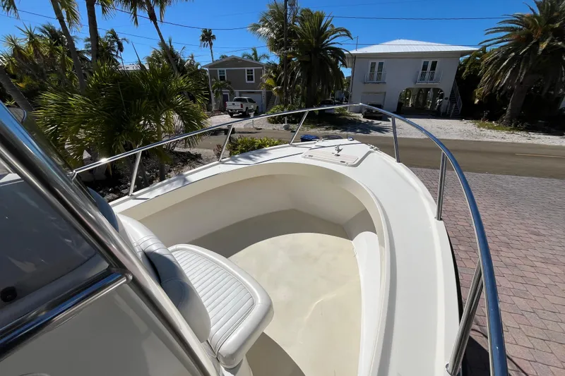 Slide: The Image of 2009 Parker 2300 Special Edition boat, white interior, parked near tropical palm trees. - 16