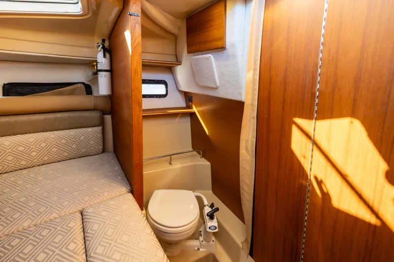 Slide: The Image of 2019 Ranger Tugs R-23 interior cabin with bed and compact bathroom. - 17