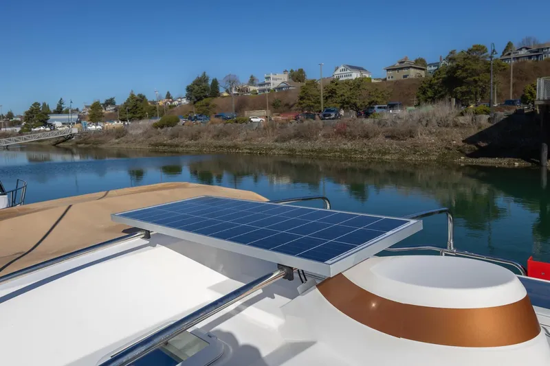 Slide: The Image of 2019 Ranger Tugs R-23 with solar panel, docked by a scenic waterfront. - 27