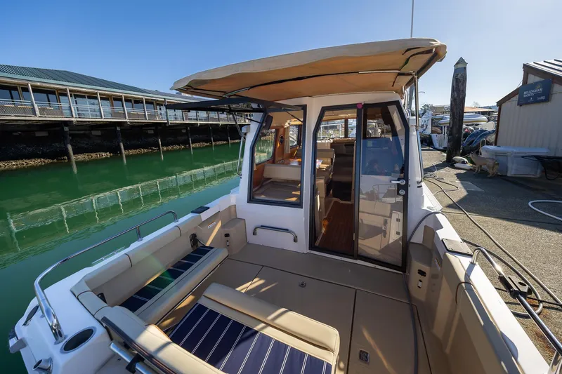 Slide: The Image of 2019 Ranger Tugs R-23 boat docked, featuring spacious seating and canopy. - 3
