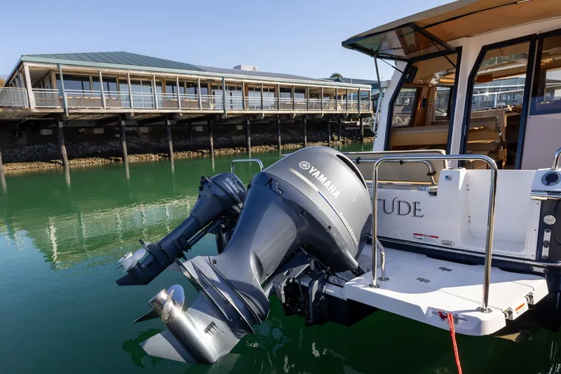 Slide: The Image of 2019 Ranger Tugs R-23 with Yamaha outboard motor docked by waterfront building. - 30
