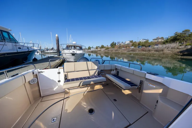 Slide: The Image of 2019 Ranger Tugs R-23 boat interior at marina, featuring seating and calm waters. - 4