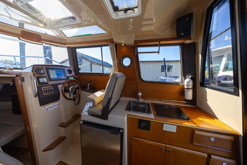 Slide: The Image of 2019 Ranger Tugs R-23 boat interior with helm, kitchen, and navigation equipment. - 8