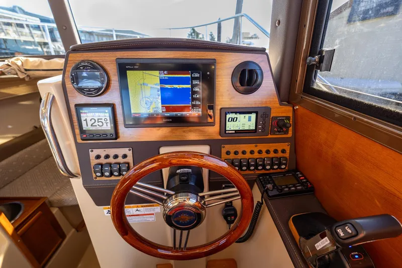 Slide: The Image of 2019 Ranger Tugs R-23 helm with navigation displays and wooden steering wheel. - 9
