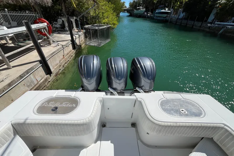 Slide: The Image of 2016 SeaHunter 35 Tournament boat with triple outboard engines docked in a canal. - 17