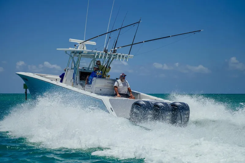 Slide: The Image of 2016 SeaHunter 35 Tournament boat cruising on ocean with fishing rods and triple engines. - 3