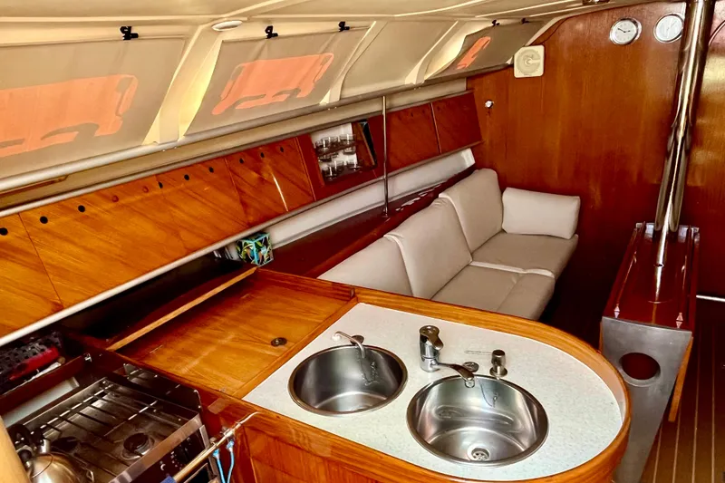 Slide: The Image of Interior of 1991 Beneteau First 38s5 yacht with kitchen and seating area. - 11