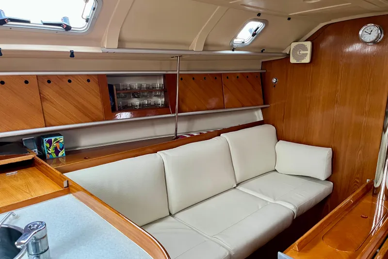 Slide: The Image of Interior of 1991 Beneteau First 38s5 yacht with white sofa and wooden cabinetry. - 12