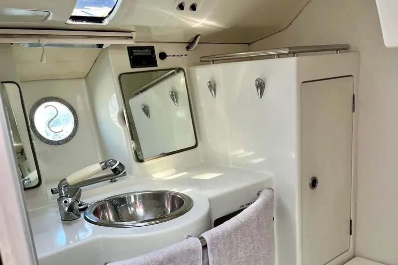 Slide: The Image of Bathroom interior of 1991 Beneteau First 38s5 yacht, featuring sink, mirror, and porthole. - 14