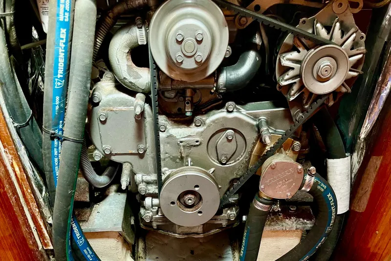Slide: The Image of Engine compartment of a 1991 Beneteau First 38s5 sailboat, featuring mechanical components and hoses. - 15
