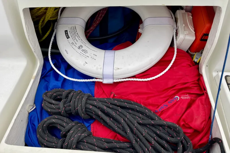 Slide: The Image of Storage compartment on a 1991 Beneteau First 38s5 with life ring, ropes, and safety gear. - 17