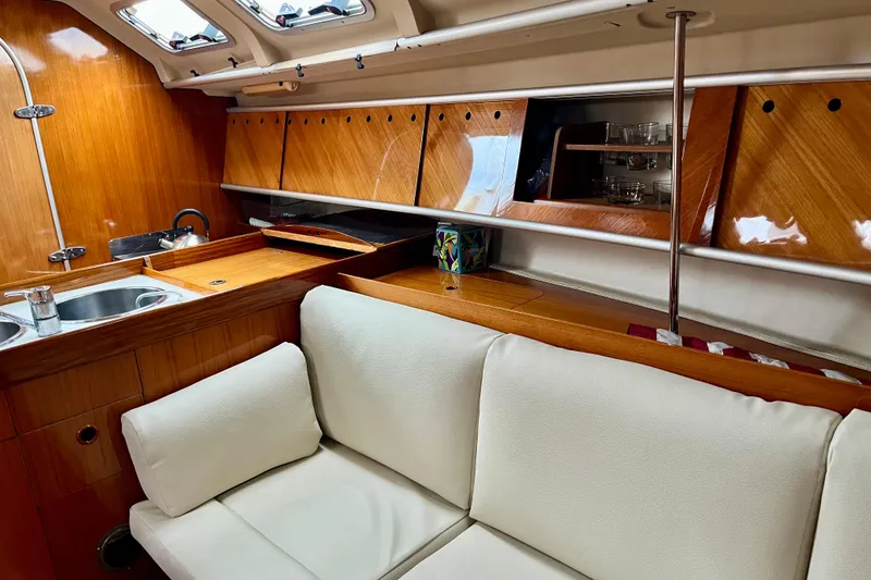 Slide: The Image of Luxurious interior of 1991 Beneteau First 38s5 yacht with wooden cabinetry and white seating. - 8