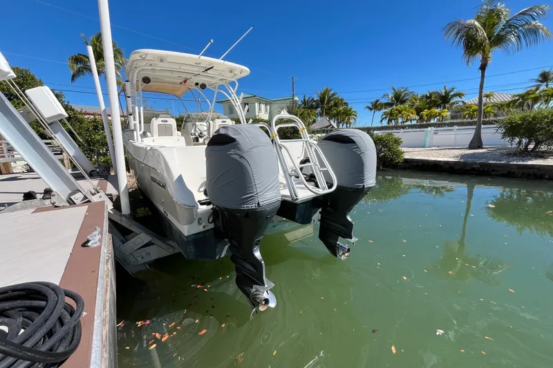 Slide: The Image of 2017 World Cat 255 DC boat docked in a sunny, tropical setting. - 2