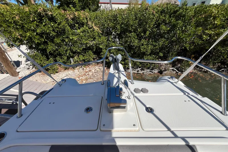 Slide: The Image of 2017 World Cat 255 DC boat deck with railing and anchor, surrounded by lush greenery. - 7