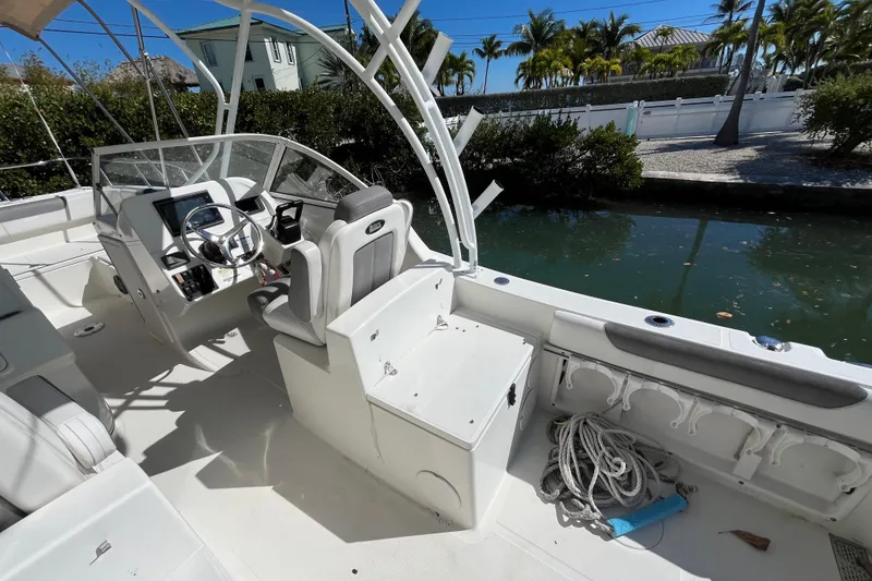 Slide: The Image of 2017 World Cat 255 DC boat interior with steering wheel, seating, and water view. - 8