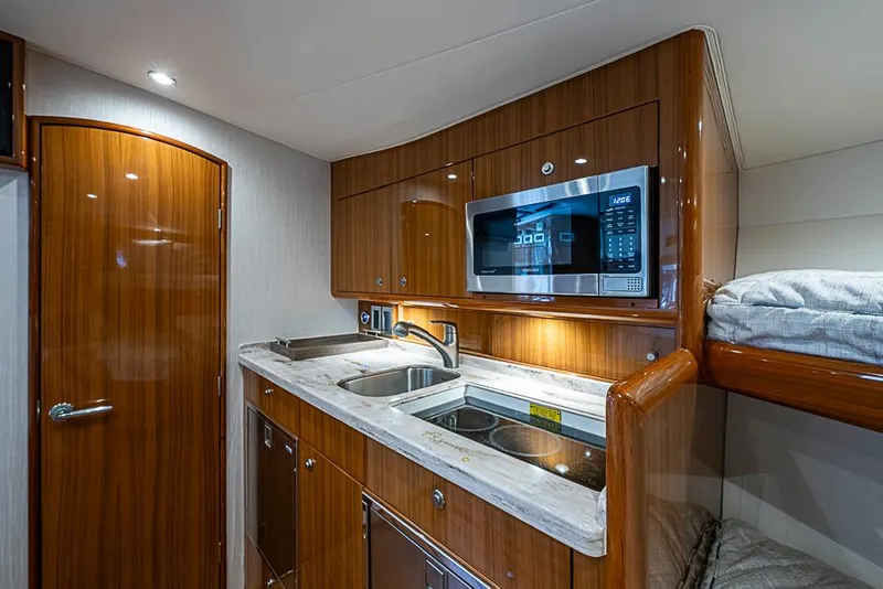 Slide: The Image of Luxurious 2021 Viking 38 Open yacht interior with modern kitchenette and wooden cabinetry. - 10