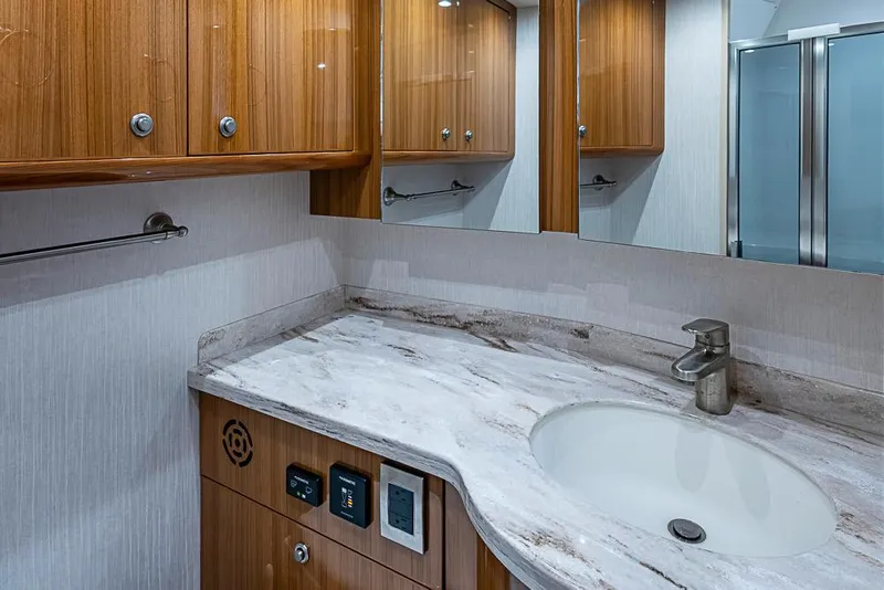 Slide: The Image of Luxurious bathroom in 2021 Viking 38 Open yacht with marble countertop and wooden cabinetry. - 17