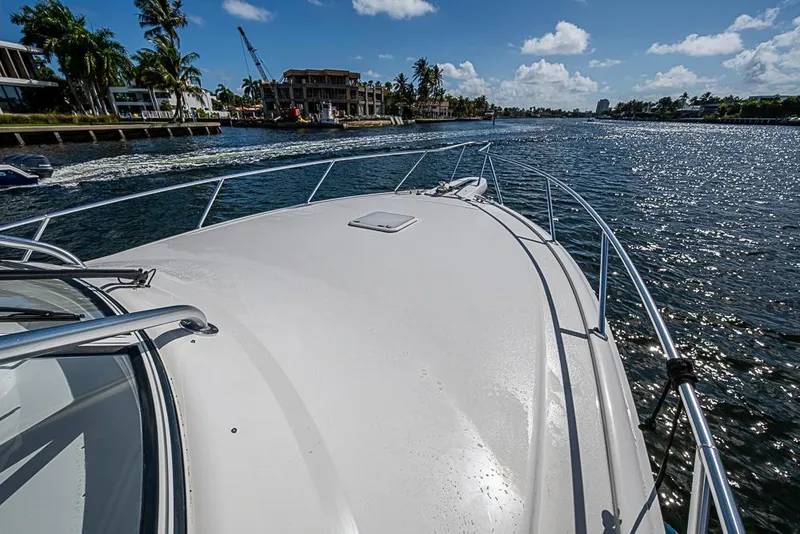 Slide: The Image of 2021 Viking 38 Open yacht cruising on a sunny waterway with palm trees. - 26