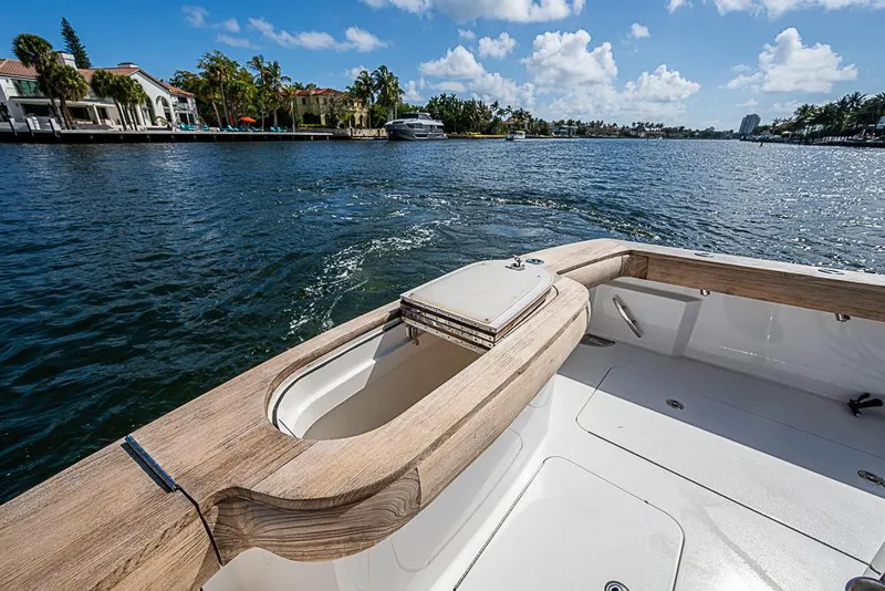 Slide: The Image of 2021 Viking 38 Open boat on a sunny day, cruising along a scenic waterfront. - 54