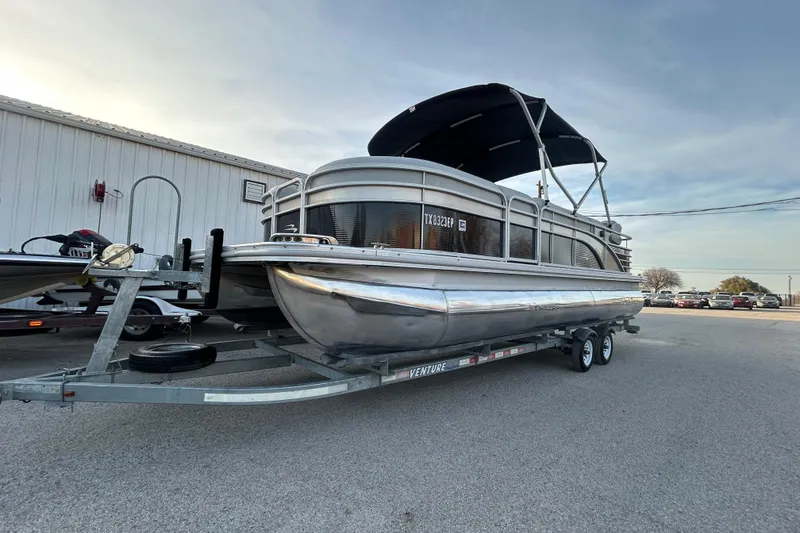 Slide: The Image of 2014 Bennington G22 pontoon boat on trailer, parked outdoors near a building. - 0