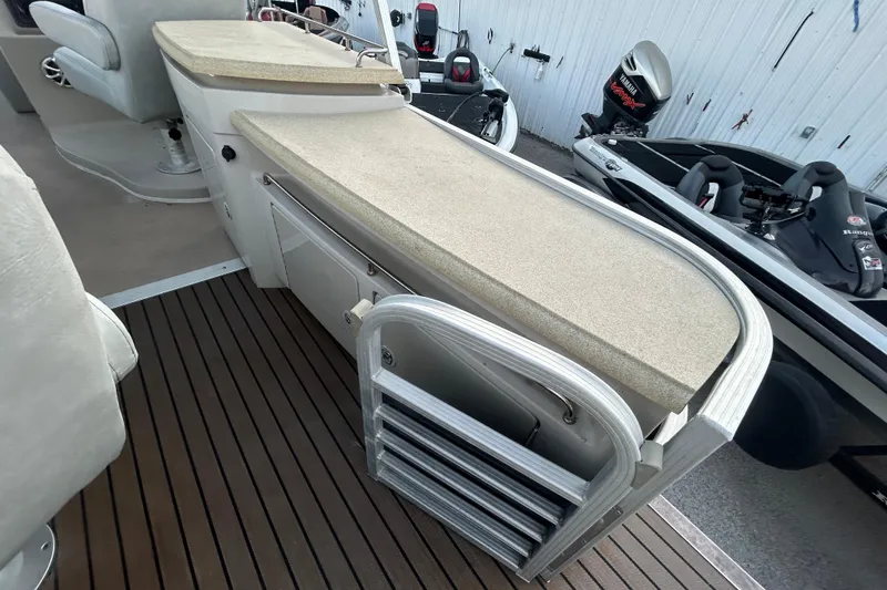 Slide: The Image of 2014 Bennington G22 boat interior with plush seating, table, and sink. - 21