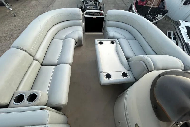 Slide: The Image of 2014 Bennington G22 pontoon boat with spacious seating and canopy, docked outdoors. - 25