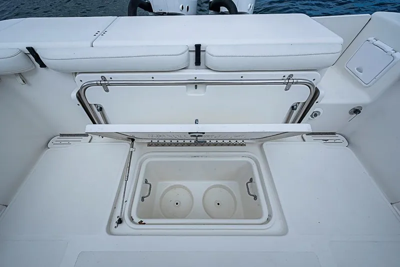 Slide: The Image of 2007 Triton 351 CC boat with open storage compartment and cushioned seating. - 12