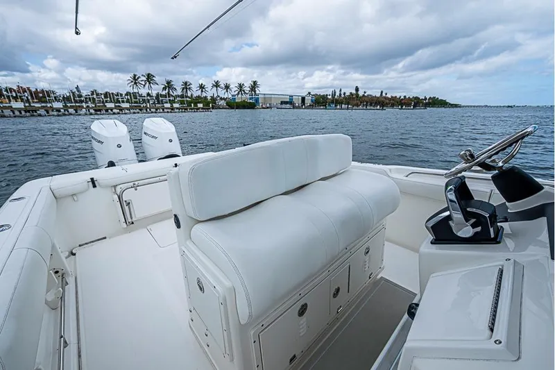 Slide: The Image of 2007 Triton 351 CC boat with dual Mercury engines on a scenic waterfront. - 14