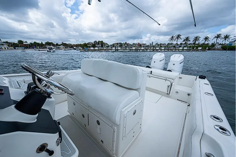 Slide: The Image of 2007 Triton 351 CC boat interior with white seating, steering wheel, and dual Mercury engines. - 15