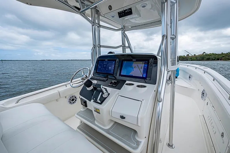 Slide: The Image of 2007 Triton 351 CC boat cockpit with navigation screens on a calm water backdrop. - 18