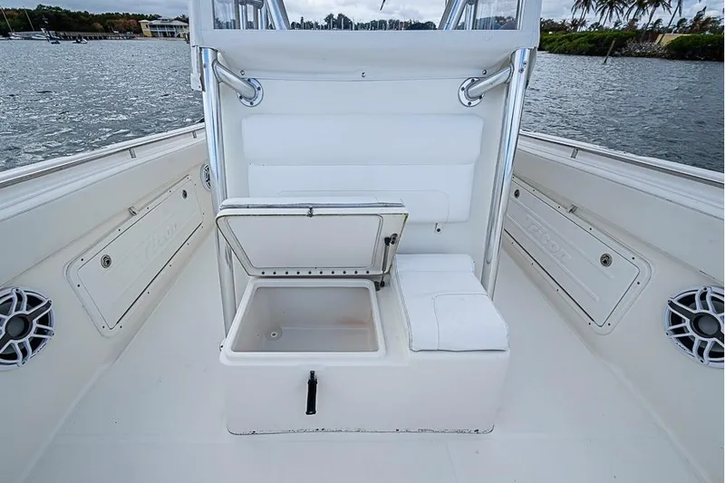 Slide: The Image of 2007 Triton 351 CC boat interior with open storage compartment, white seating, and water view. - 24