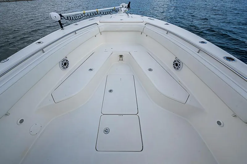 Slide: The Image of 2007 Triton 351 CC boat deck with spacious seating and storage, on calm water. - 28