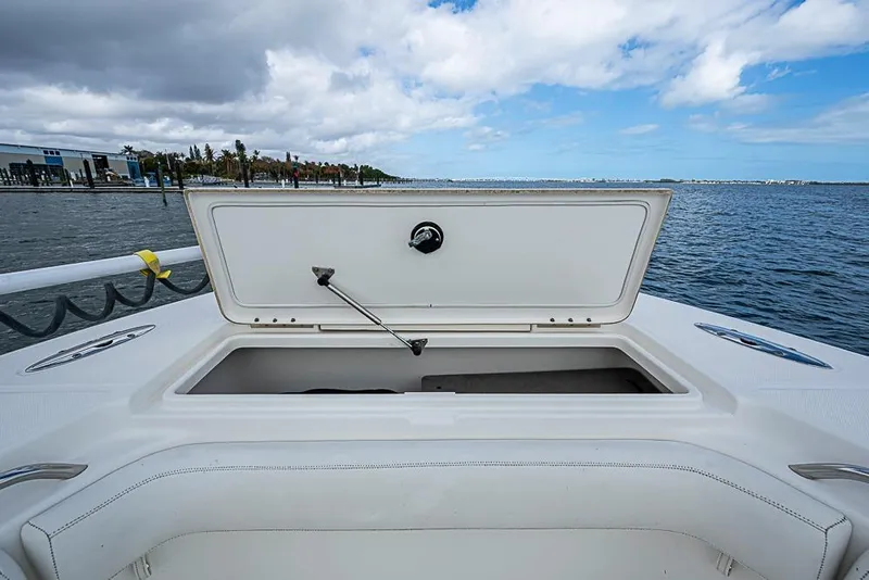 Slide: The Image of Open storage compartment on 2007 Triton 351 CC boat, with ocean and cloudy sky background. - 31
