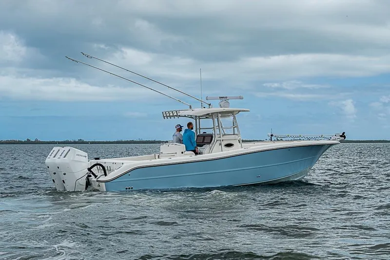 Slide: The Image of 2007 Triton 351 CC boat cruising on open water under cloudy skies. - 37