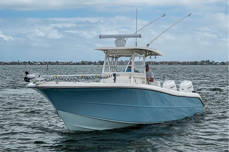Slide: The Image of 2007 Triton 351 CC boat cruising on open water under a cloudy sky. - 38