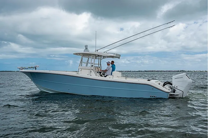 Slide: The Image of 2007 Triton 351 CC boat on water with two people. - 39