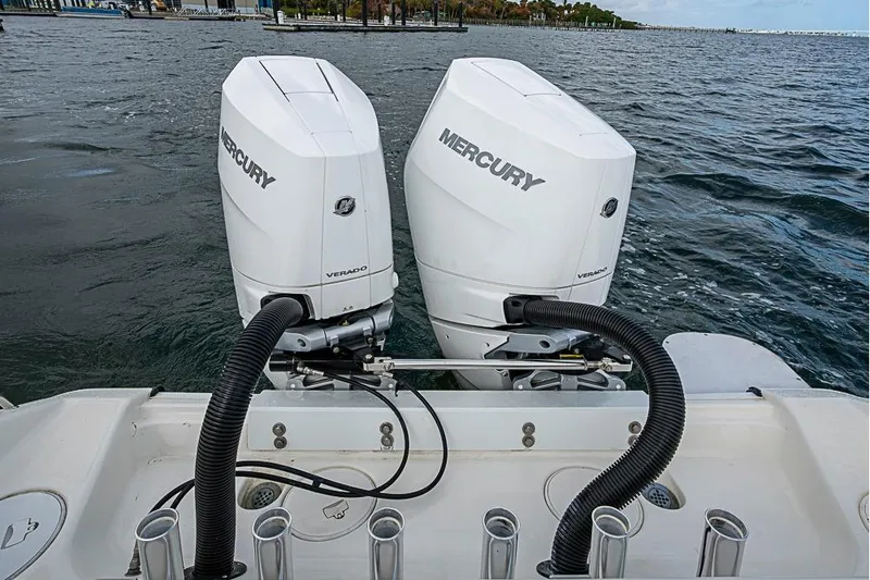 Slide: The Image of Twin Mercury Verado engines on a 2007 Triton 351 CC boat, docked on a calm sea. - 6