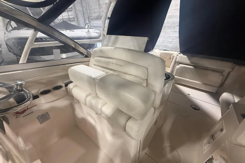 Slide: The Image of 2022 Grady-White Freedom 307 boat interior with white seating and steering wheel. - 26