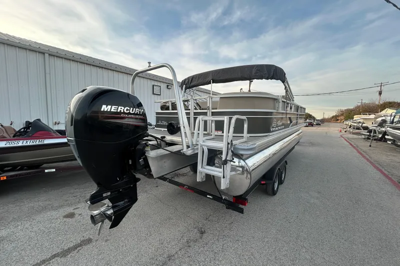 Slide: The Image of 2017 Sun Tracker Party Barge 24 DLX pontoon boat on trailer, parked outdoors. - 13