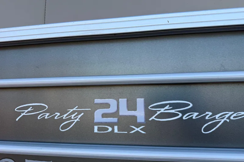 Slide: The Image of 2017 Sun Tracker Party Barge 24 DLX logo on metallic surface. - 27